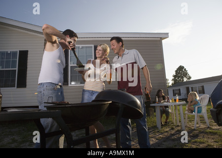 Blue collar families enjoying a cookout in front of trailer home Stock Photo