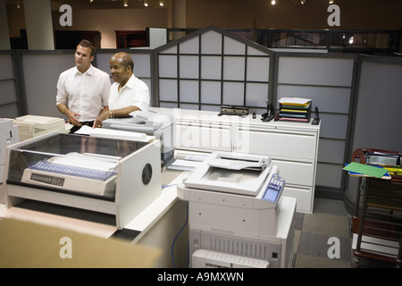 Mature businessman conferring with younger male colleague  in an office Stock Photo