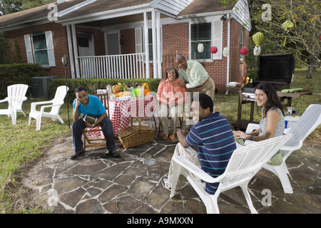 Young interracial couple enjoying backyard bbq with family Stock Photo