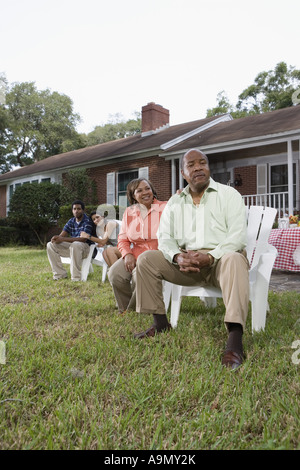 Portrait of interracial couple and parents relaxing in backyard Stock Photo