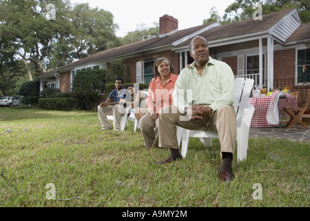 Portrait of interracial couple and parents relaxing in backyard Stock Photo