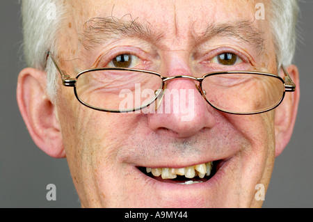 elderly man horizontal close up peering over glasses Stock Photo