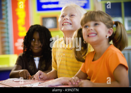 Kids posing and smiling together in a colorful classroom Stock Photo