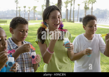 Children blowing bubbles at a park Stock Photo