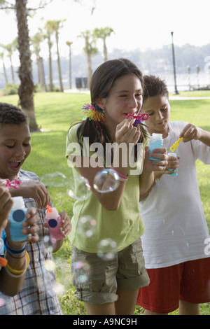 Children blowing bubbles at a park Stock Photo