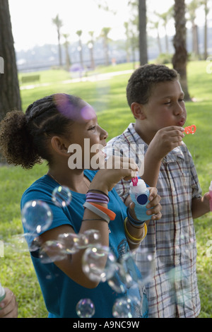 Children blowing bubbles at a park Stock Photo
