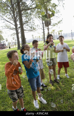 Children blowing bubbles at a park Stock Photo