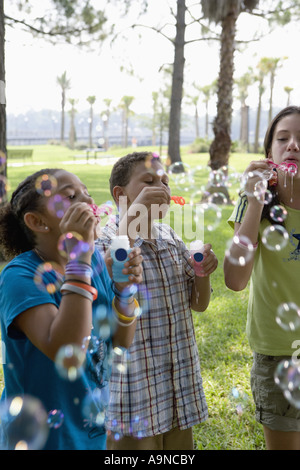 Children blowing bubbles at a park Stock Photo
