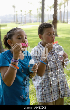 Children blowing bubbles at a park Stock Photo