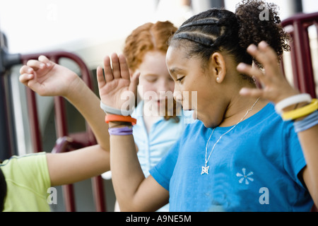 Three girls jumping and dancing at a playground Stock Photo