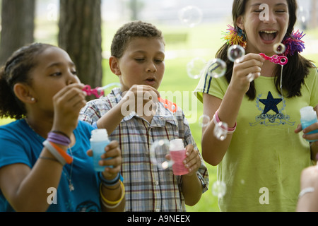 Children blowing bubbles at a park Stock Photo