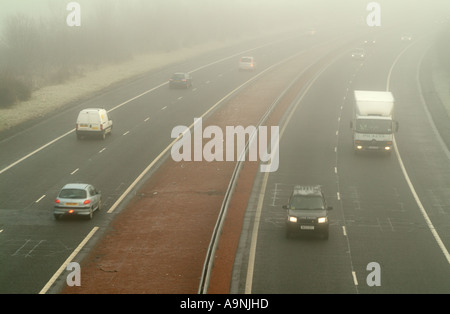 Busy traffic driving through fog on the M8 motorway near Ratho, Edinburgh, Scotland, UK. Stock Photo