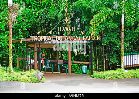 Image showing the entrance gates to the Hawaii Tropical Garden near Hilo with a young Hawaiian waiting to greet visitors Stock Photo