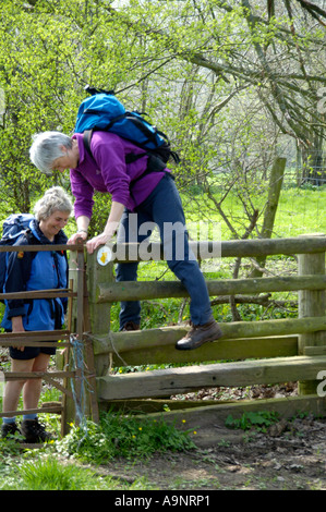 Guided walking group crossing stile on footpath to Longtown in the Black Mountains Herefordshire England UK Stock Photo