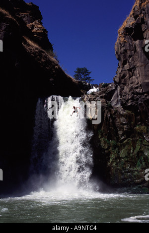 A man leaping off a 40 foot waterfall on the White River OR Stock Photo