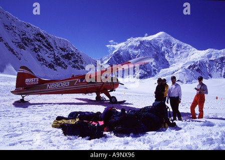 A mountaineering expedition unloading gear from ski plane on the Kahiltna glacier near Denali AK Stock Photo