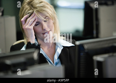 Businesswoman suffering from a headache working in an office Stock Photo