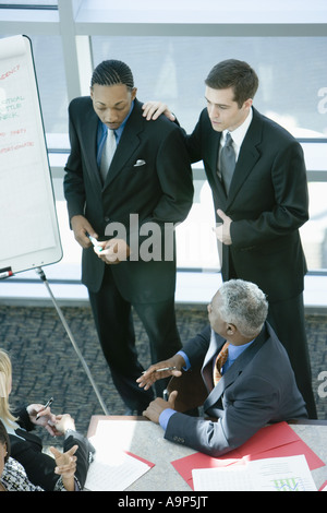 Two young businessmen giving presentation to executives Stock Photo
