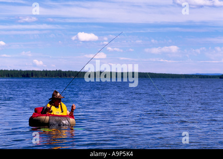 Fly Fisherman in a Belly Boat fishing for Trout in Hi Hium Lake in the Cariboo Region of British Columbia Canada Stock Photo