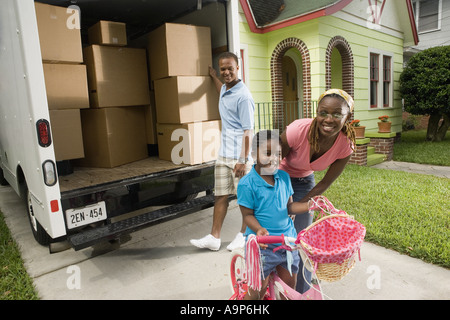 Portrait of family next to moving truck Stock Photo