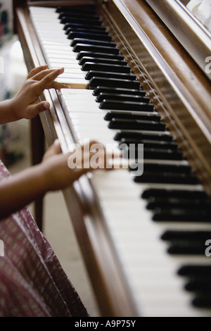 Close-up of a little girl's hands playing piano Stock Photo
