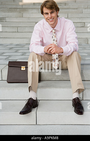 Businessman sitting on steps Stock Photo