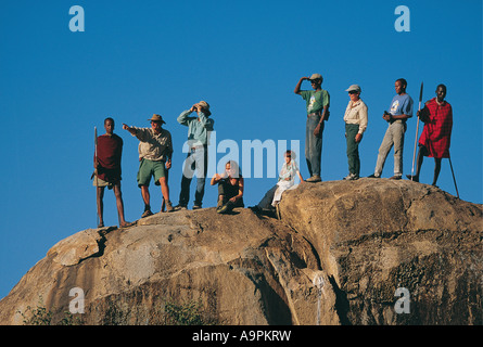 Group of tourists with their African and Maasai guides on a game walk Serengeti National Park Tanzania Stock Photo