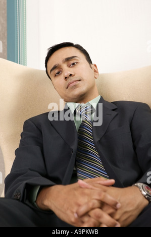 Asian Businessman Sitting On Chair With Leg Crossed Holding Laptop In ...
