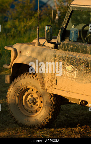 Mud covered Land Rover Defender 90 soft top with Land Rover Experience signet. Stock Photo
