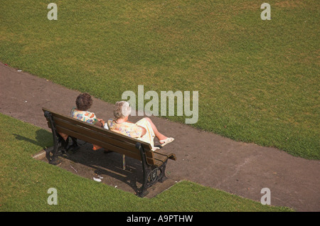 Two older ladies enjoying a sunny afternoon on a park bench Stock Photo