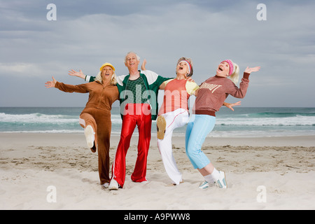 Four senior adults exercising on beach Stock Photo