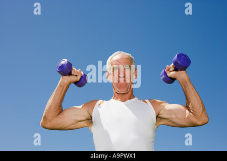 Senior adult man lifting dumbells Stock Photo