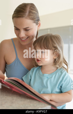 Mother helping her daughter to read Stock Photo