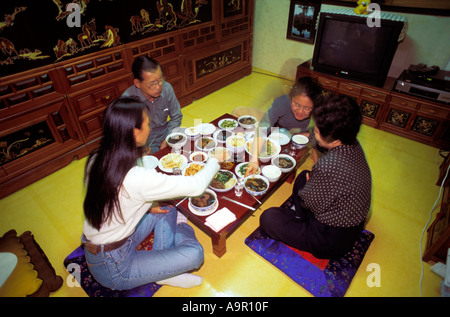 Korean family eating traditional food in typical home setting