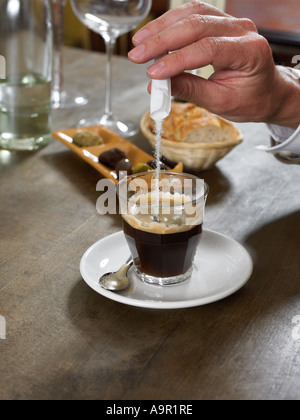 Man adding sugar to espresso coffee Stock Photo