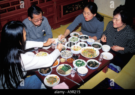 Korean family eating traditional food in typical home setting
