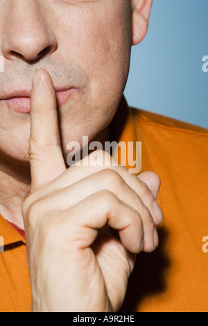 Man with finger on lips Stock Photo