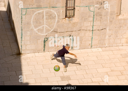 Boy throwing ball from makeshift goal drawn onto wall Dubrovnik Croatia Stock Photo
