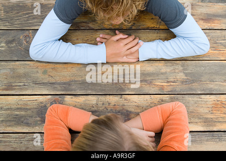 Two teenagers sat facing each other Stock Photo