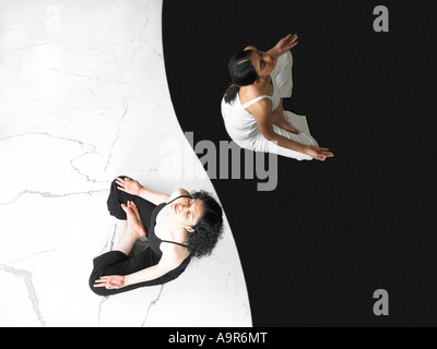 Two women meditating in Lotus position Studio shot Stock Photo