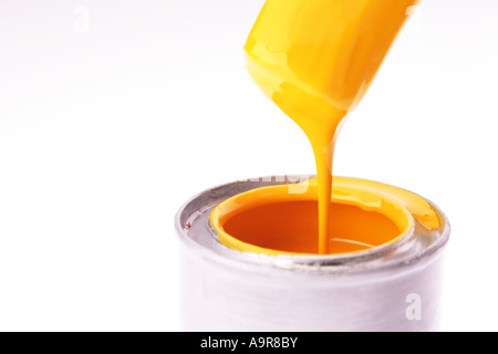Paint brush dipped in can of yellow paint Stock Photo