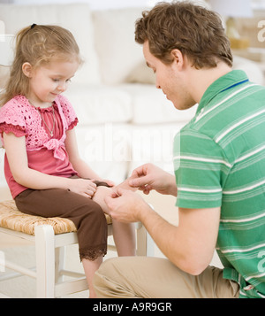 Father putting bandage on daughter Stock Photo