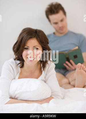 Colour portrait of nude couple in bed holding each other Stock Photo