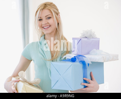 Woman holding stack of gifts Stock Photo