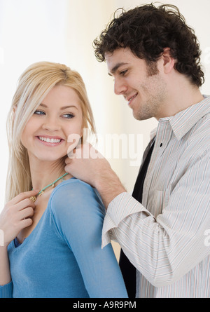 Man putting necklace on girlfriend Stock Photo