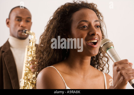 Woman singing into microphone Stock Photo