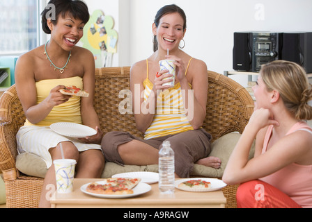 Multi ethnic women eating pizza Stock Photo