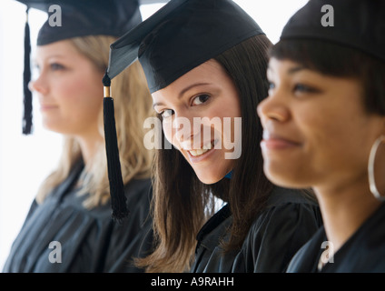 Multi ethnic women wearing graduation cap and gown Stock Photo