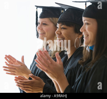 Multi ethnic women wearing graduation cap and gown Stock Photo