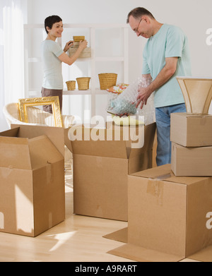 Couple unpacking moving boxes Stock Photo